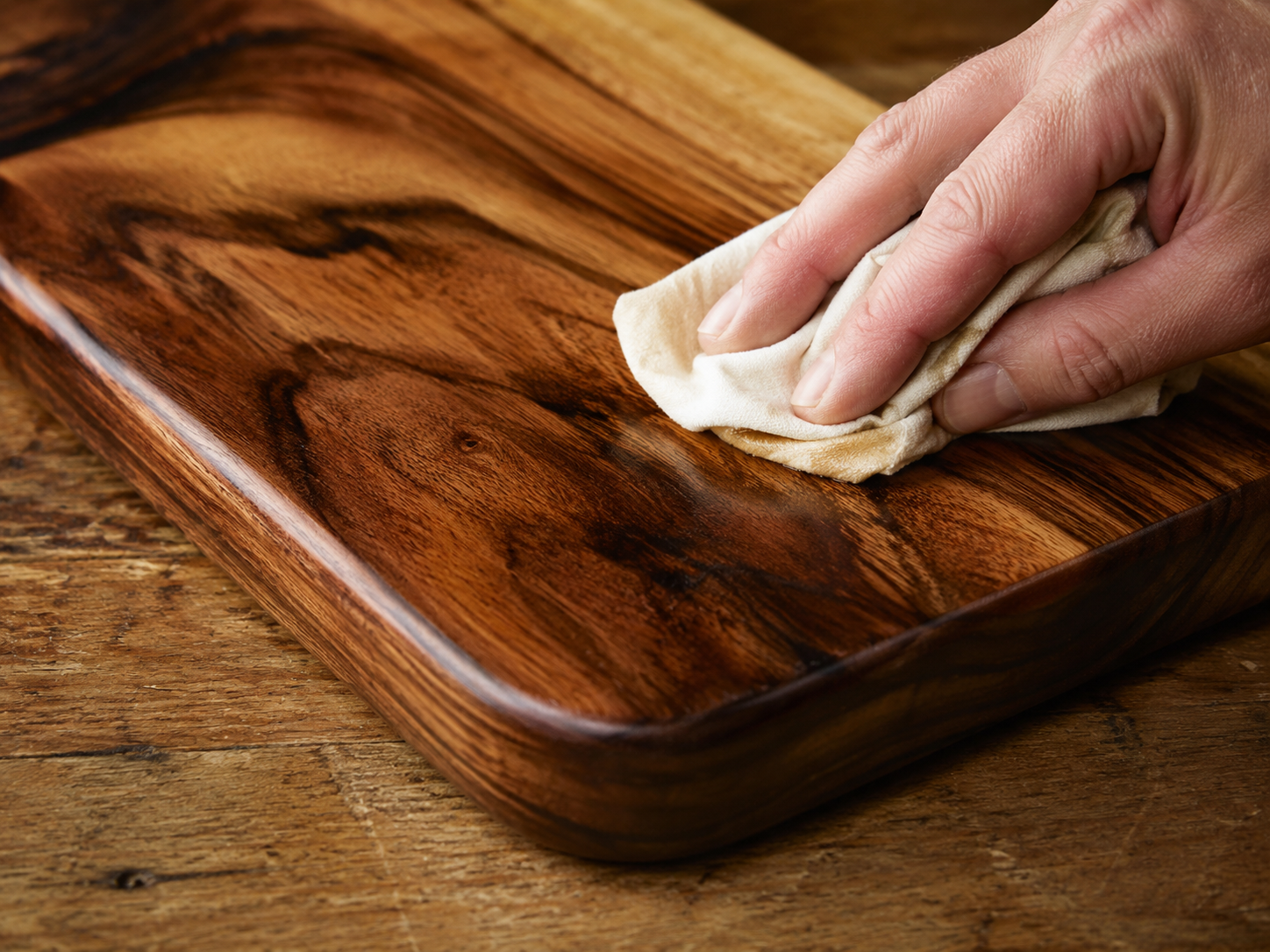 Applying oil to a handmade wooden chopping board